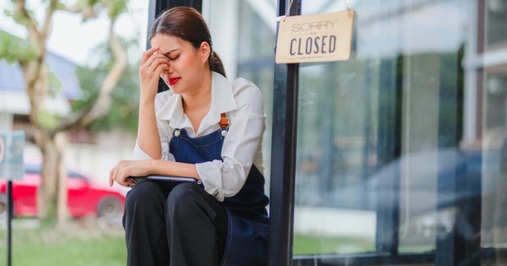 Sad small business owner sitting in front of her closed shop; OP-ED: No power, no paychecks, Why West Virginia's grid matters